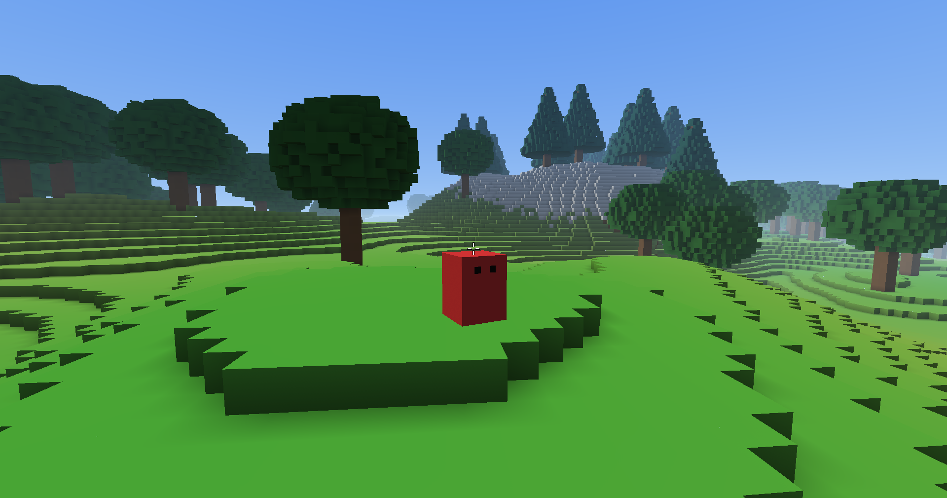 The player, a red block with two eyes, stands on a grassy terrace of wide flat steps, with round oaks nearby and pines on a snowy hill behind.
