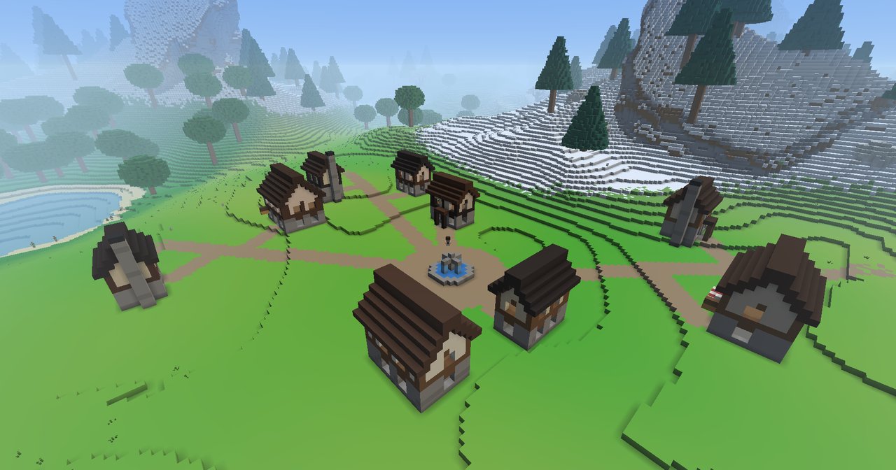 A town seen from above: timber-framed houses with brown roofs round a dirt square with a blue fountain in the middle, dirt roads running out across the grass, a lake to the left and snowy pine slopes to the right.